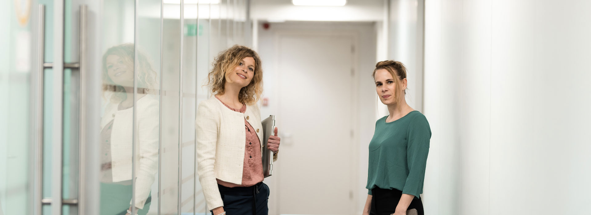 twee-vrouwen-in-hal-met-laptop-onder-arm