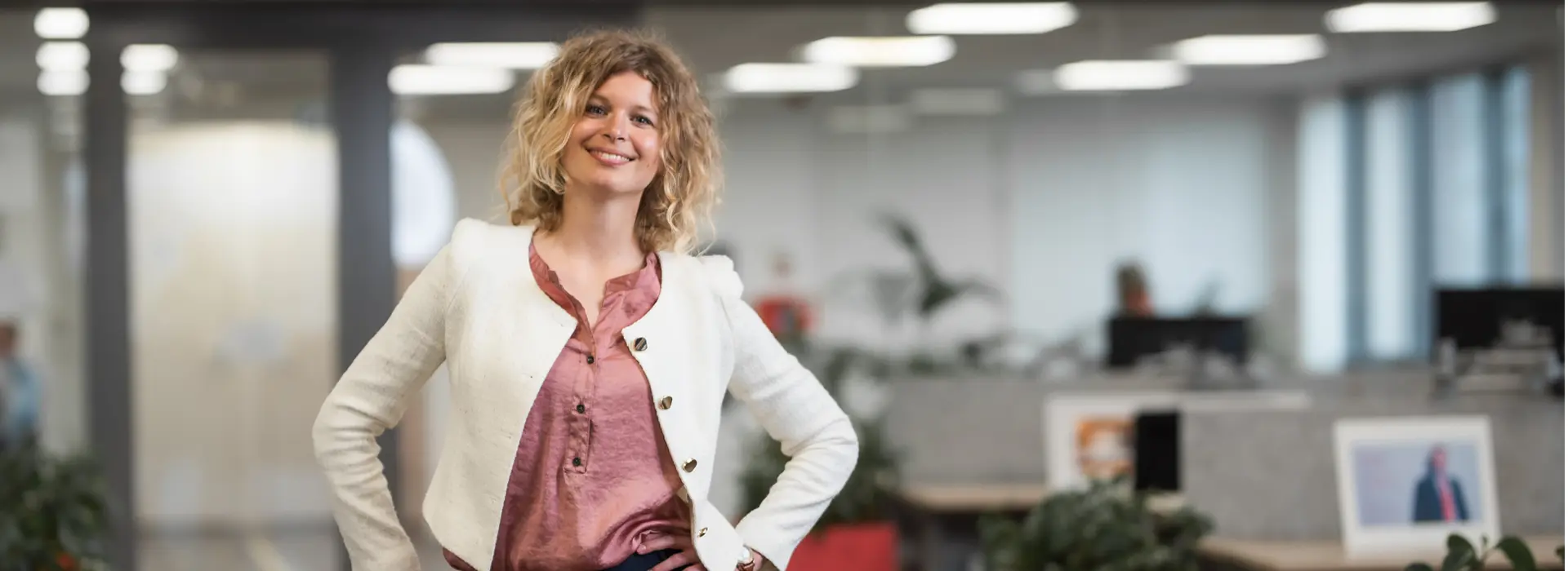 Vrouw-in-kantoortuin-met-armen-in-zij