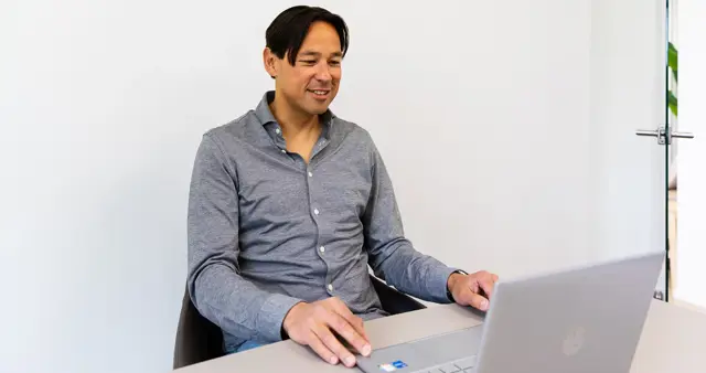 Man-achter-laptop